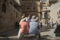 Tourists sit outside the Church of the Holy Sepulchre, traditionally ...
