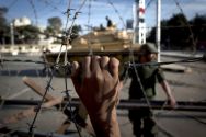 An Egyptian army tank is seen behind barbed wire securing the ...