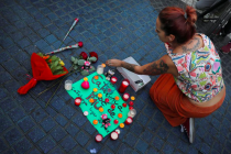 a-woman-places-a-candle-on-a-placard-reading-in-spanish-and-catalan-catalonia-place-of-peace-in-the-area-where-a-van-crashed-into-pedestrians-at-las-ramblas-street-in-barcelona-spain-august-18-2017