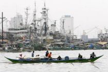 Fishermen head to sea in Manila Bay near a fishing village in ...